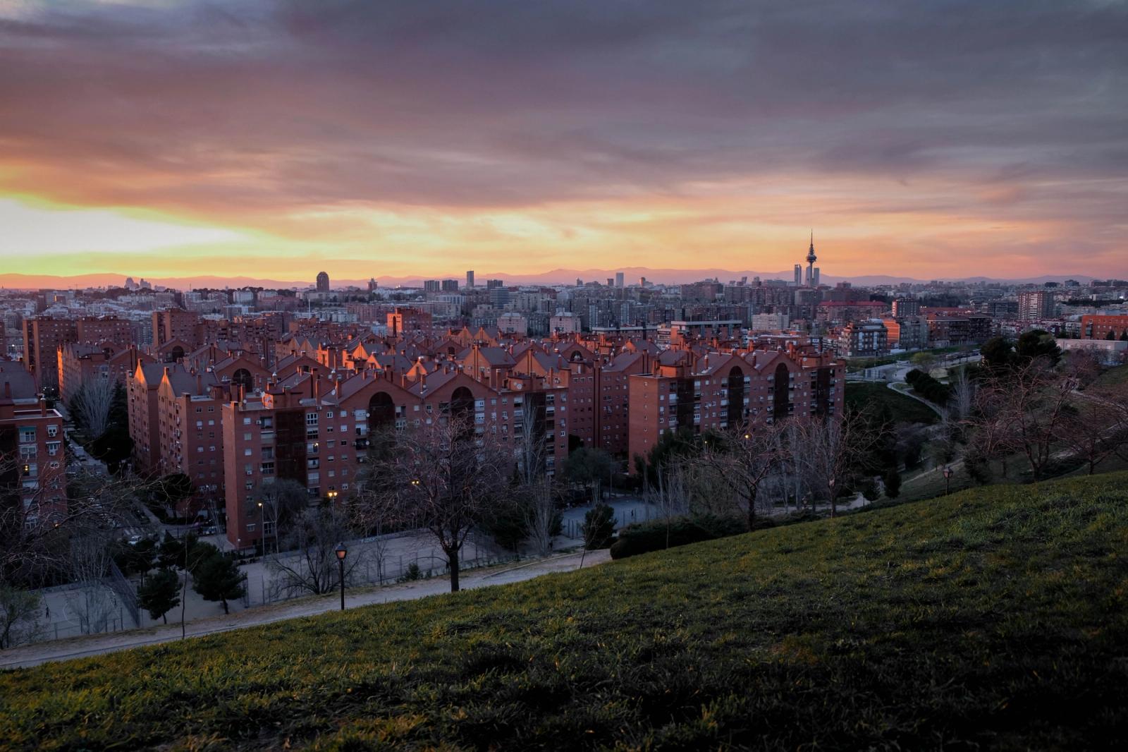 Captivating view of Madrid's skyline at sunset from a park, showcasing urban architecture