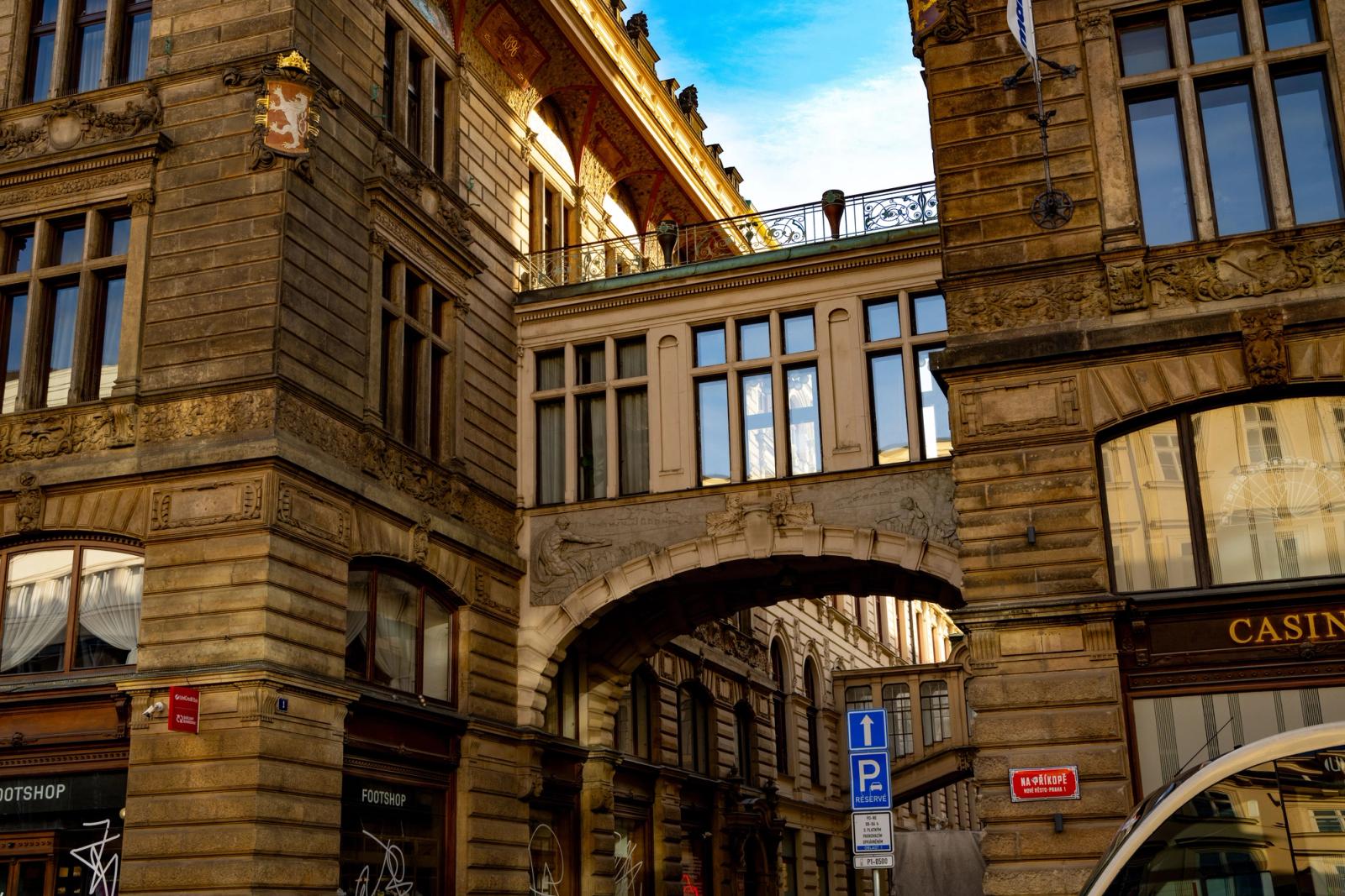 A stunning view of historic buildings and a sky bridge in Prague, highlighting intricate architectural details under clear skies