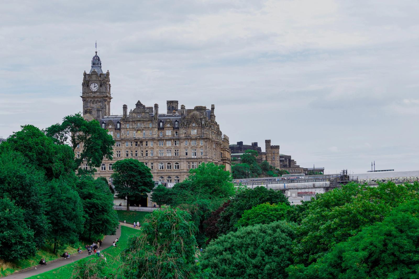 Stunning view of the Victorian Balmoral Hotel amidst lush greenery in Edinburgh, Scotland