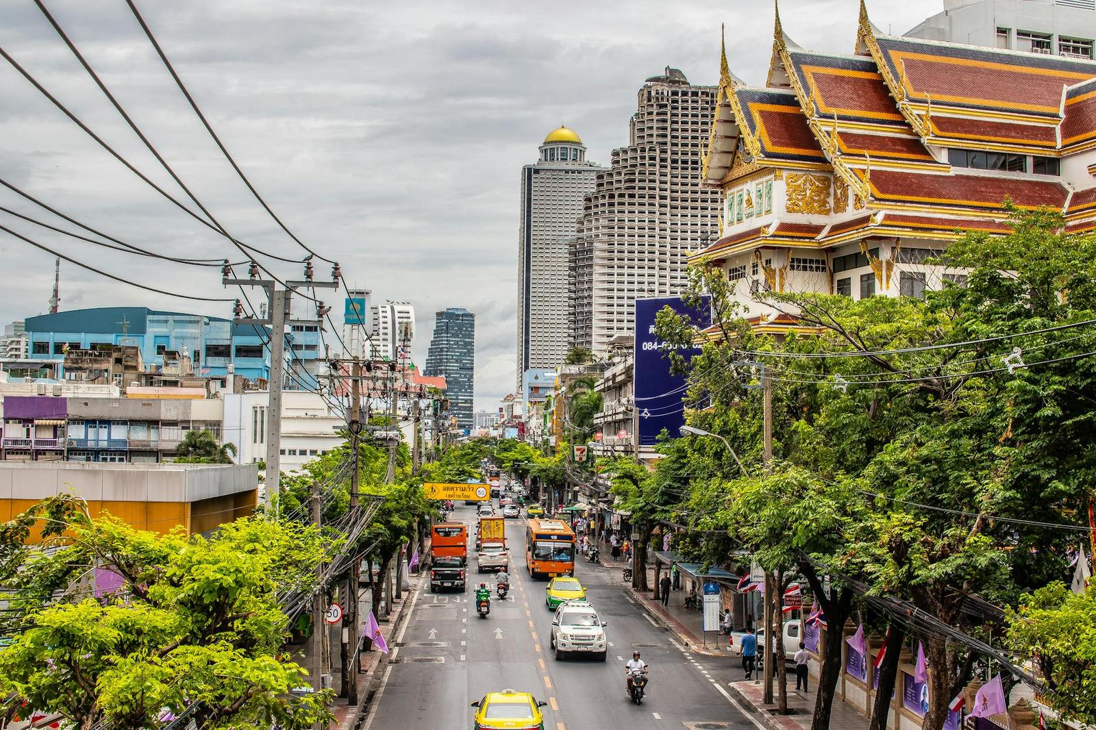 Ornate temple rooftop rising beside a busy city avenue