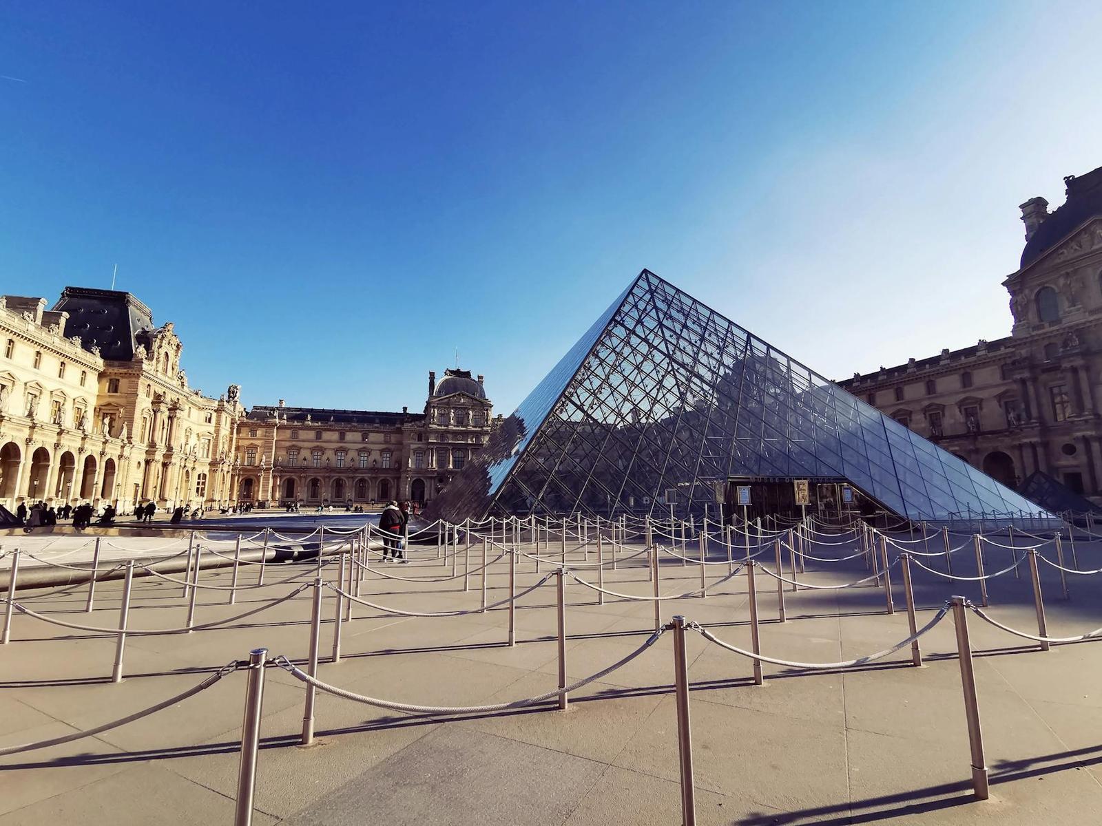 Louvre Pyramid in Paris with bright sky