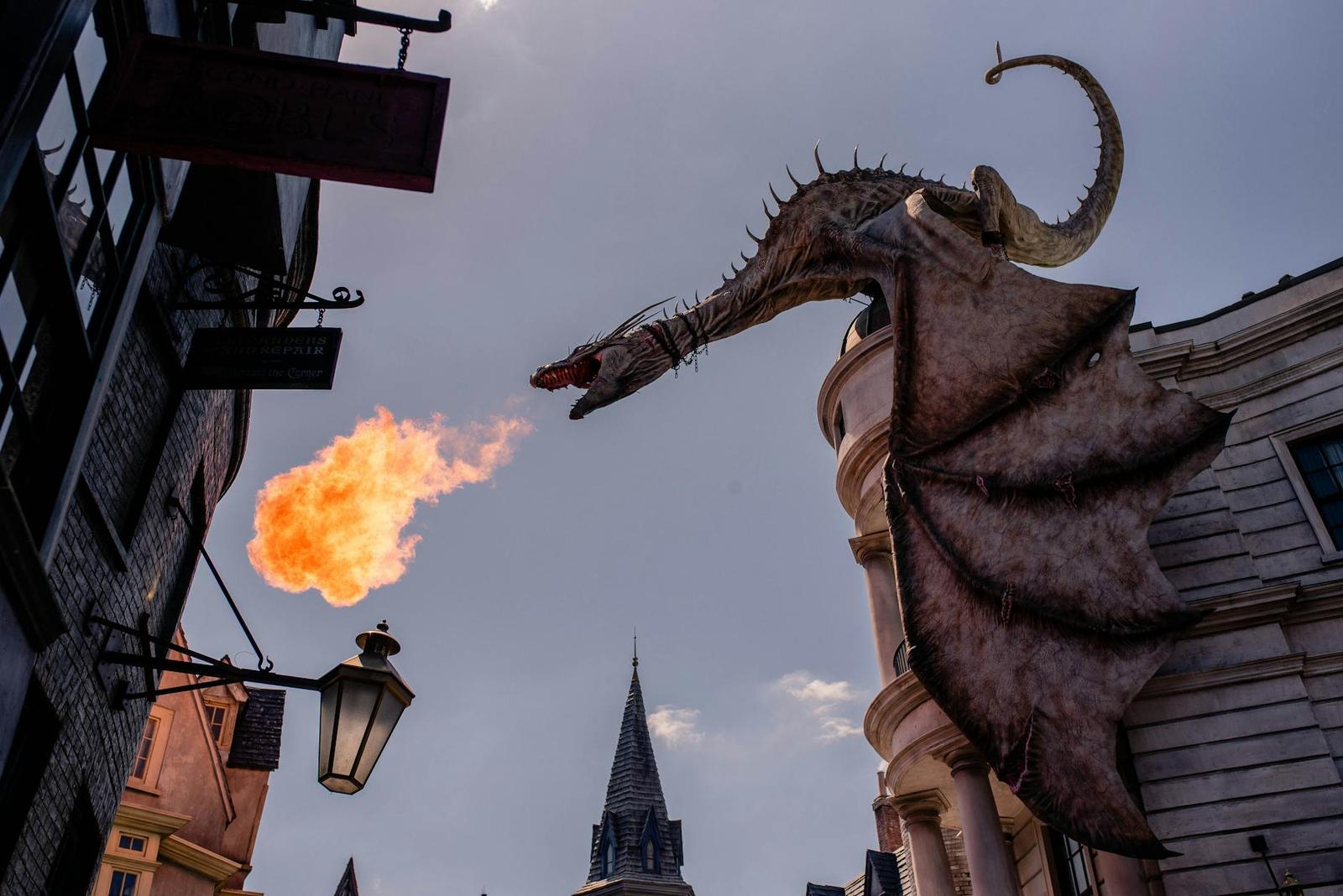 Fire-breathing dragon sculpture perched atop a themed building facade