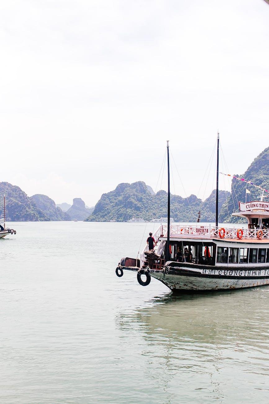 Wooden cruise boat anchored with limestone islets in the background