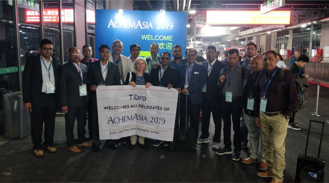 A group of people standing together in front of a large banner.