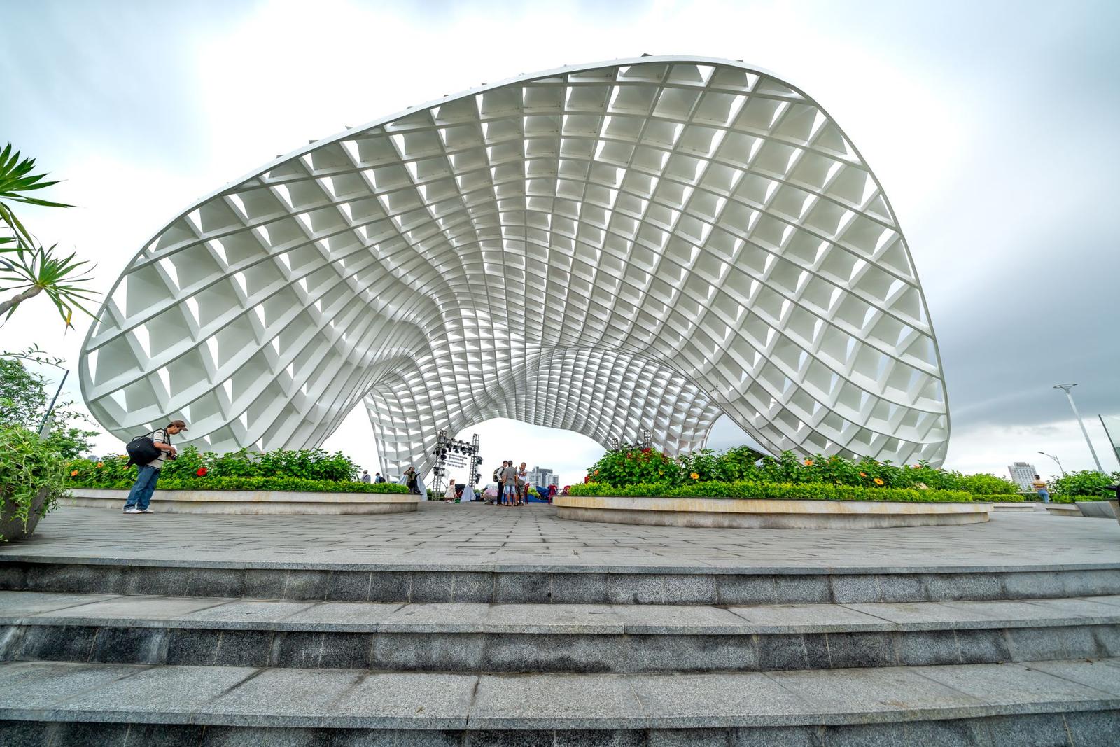The iconic Apec Park landmark in Da Nang, Vietnam, featuring tourists and a cloudy sky