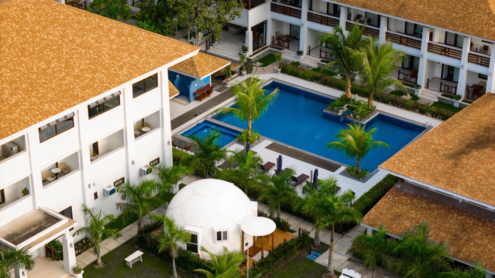 Stunning aerial view of a tropical resort in El Nido with pool and lush palm trees
