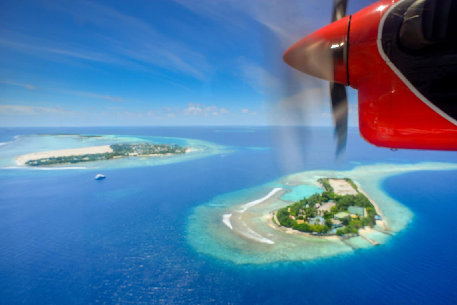 A stunning aerial shot of Maldivian islands captured from a seaplane, showcasing turquoise waters and lush landscapes