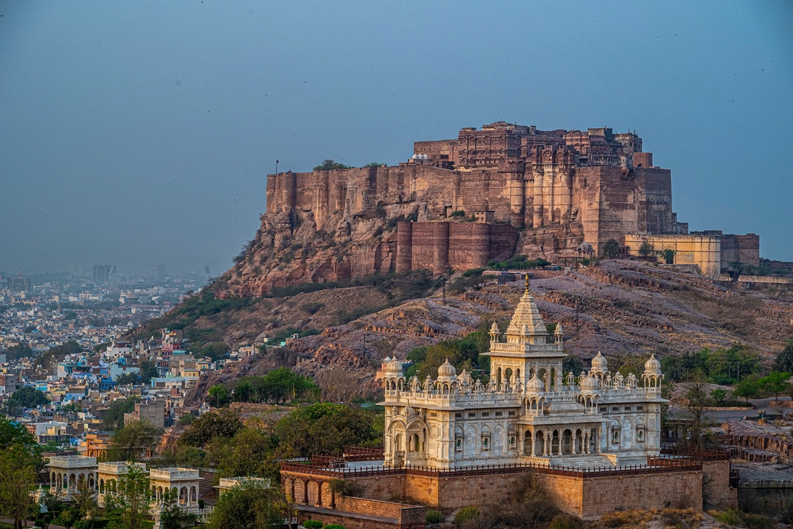 A hilltop sandstone fort towering above a white marble cenotaph