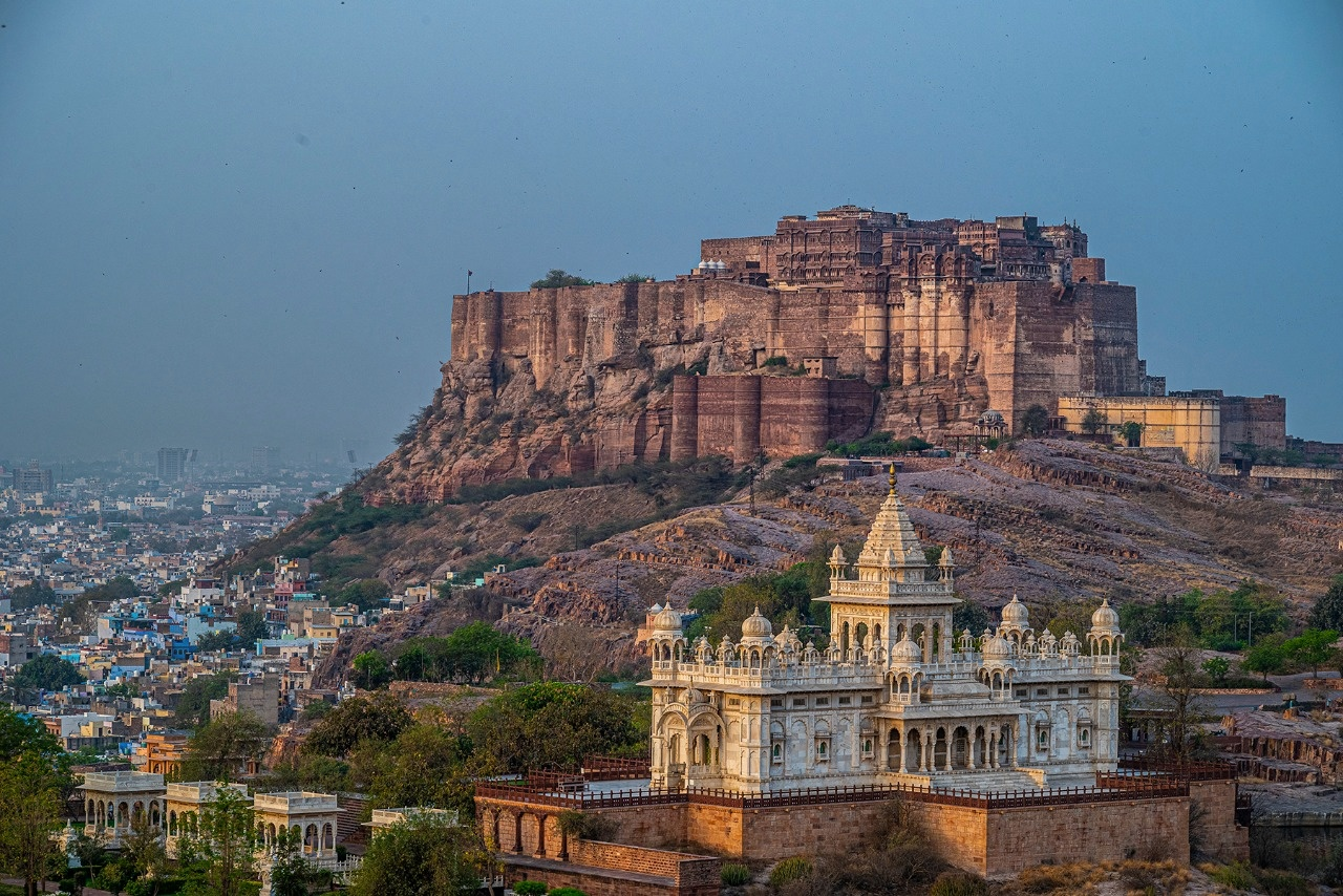 A hilltop sandstone fort towering above a white marble cenotaph