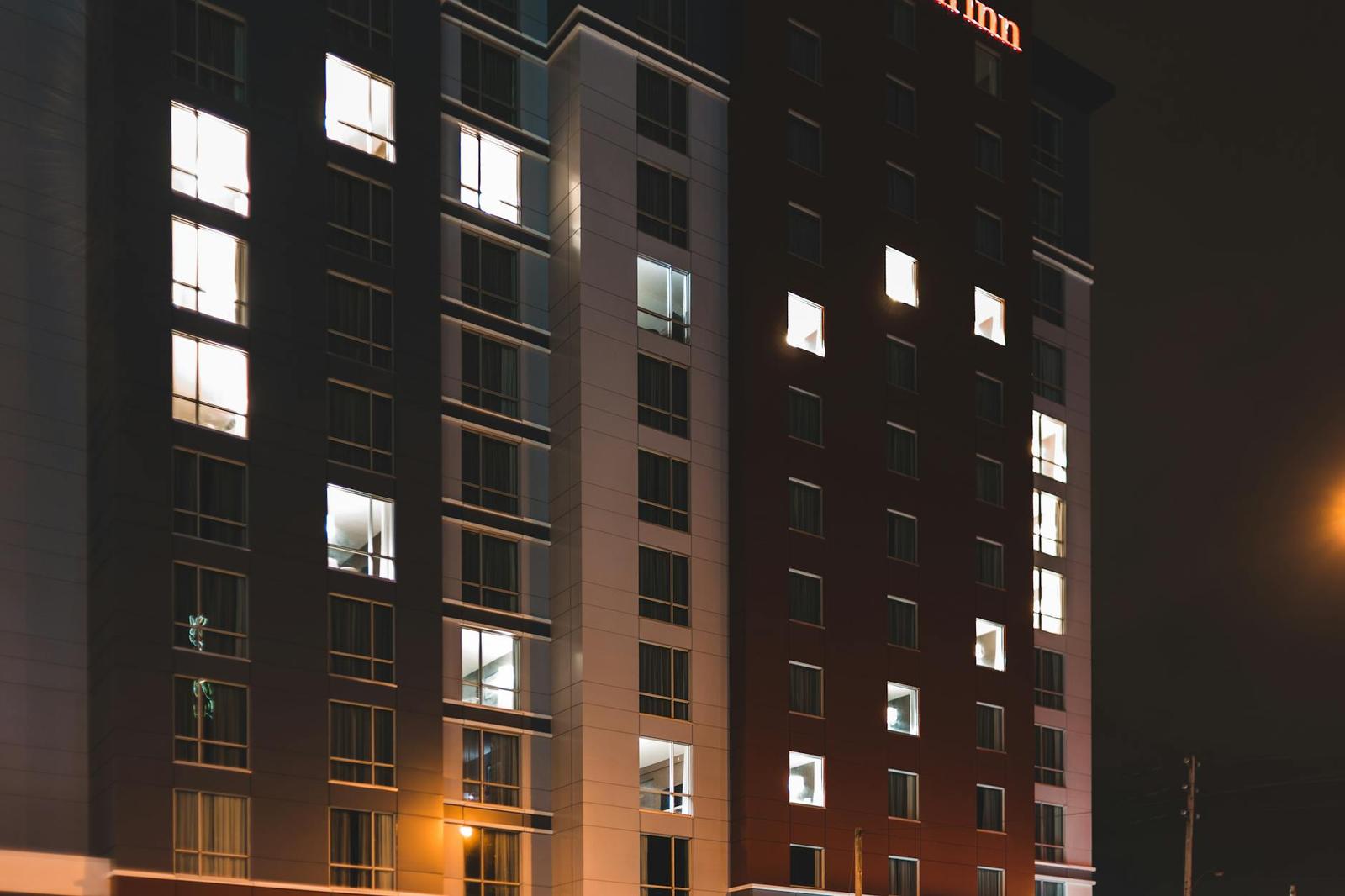 A tall hotel building with lit windows photographed at night