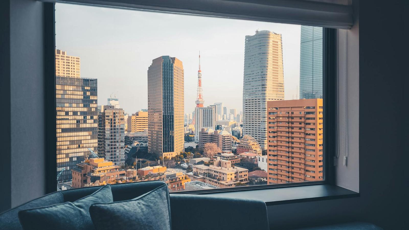 City skyline with a red lattice tower seen through a hotel room window
