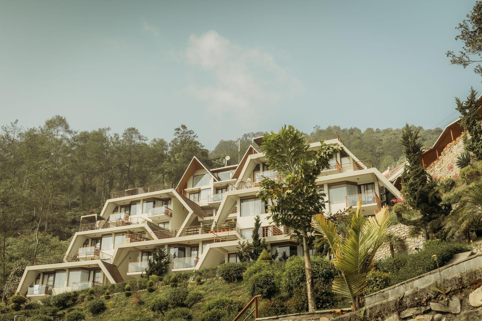 Contemporary villas stepped into a forested hillside above the Doon valley