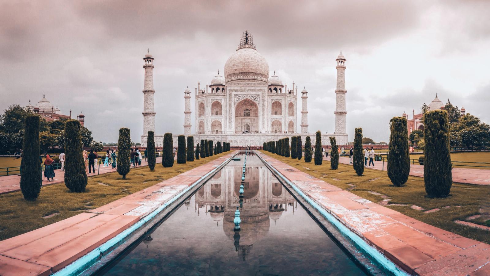 Iconic view of the Taj Mahal with reflection in Agra, India during sunset, highlighting its architectural symmetry