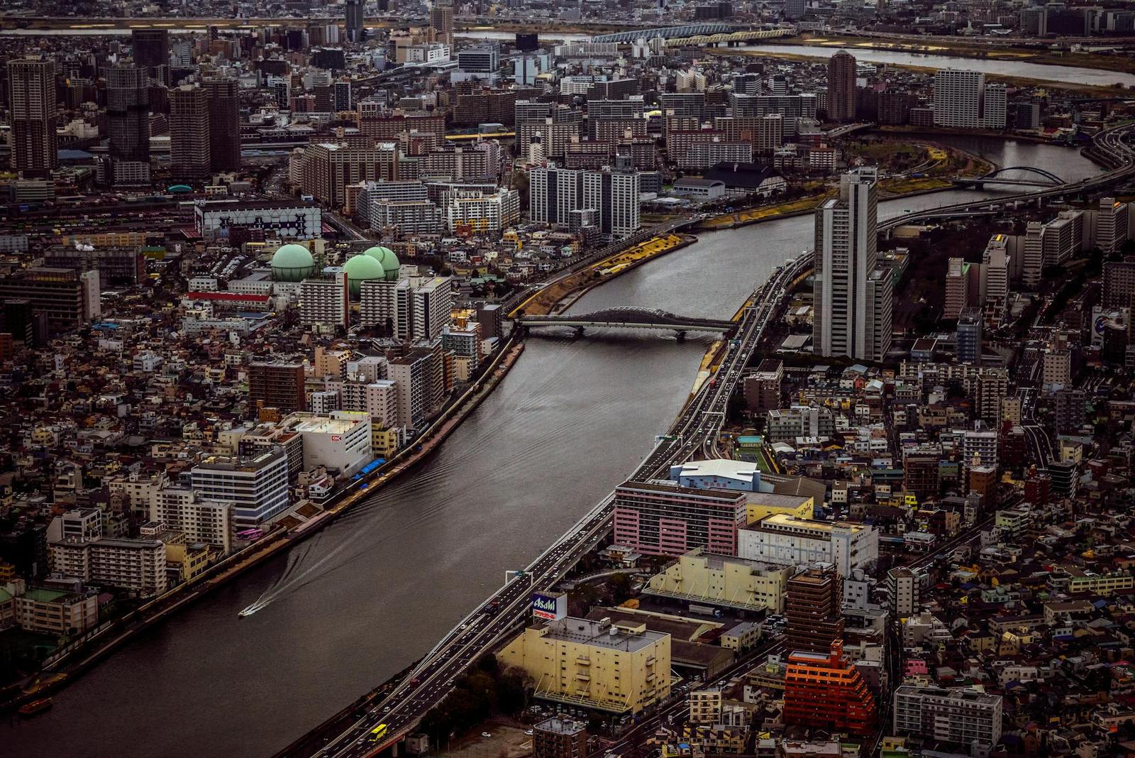 Aerial view of a dense city divided by a wide river and bridges