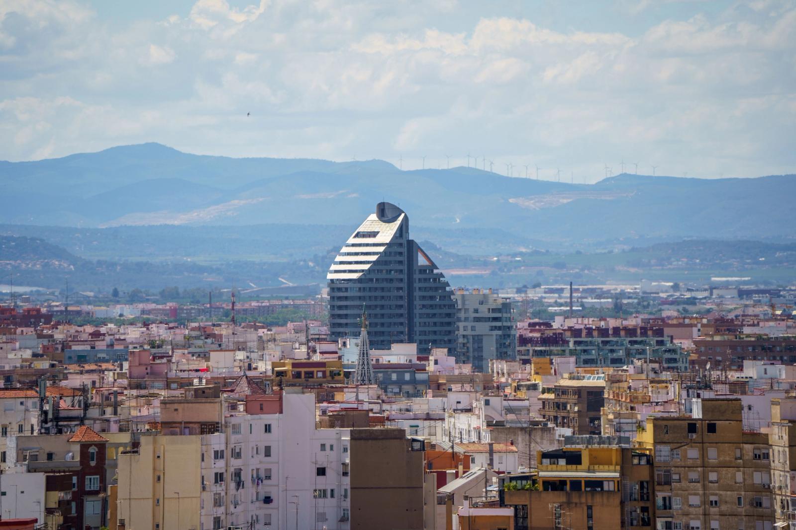 A stunning aerial view of Valencia, Spain featuring the prominent Navis Building against a mountainous backdrop