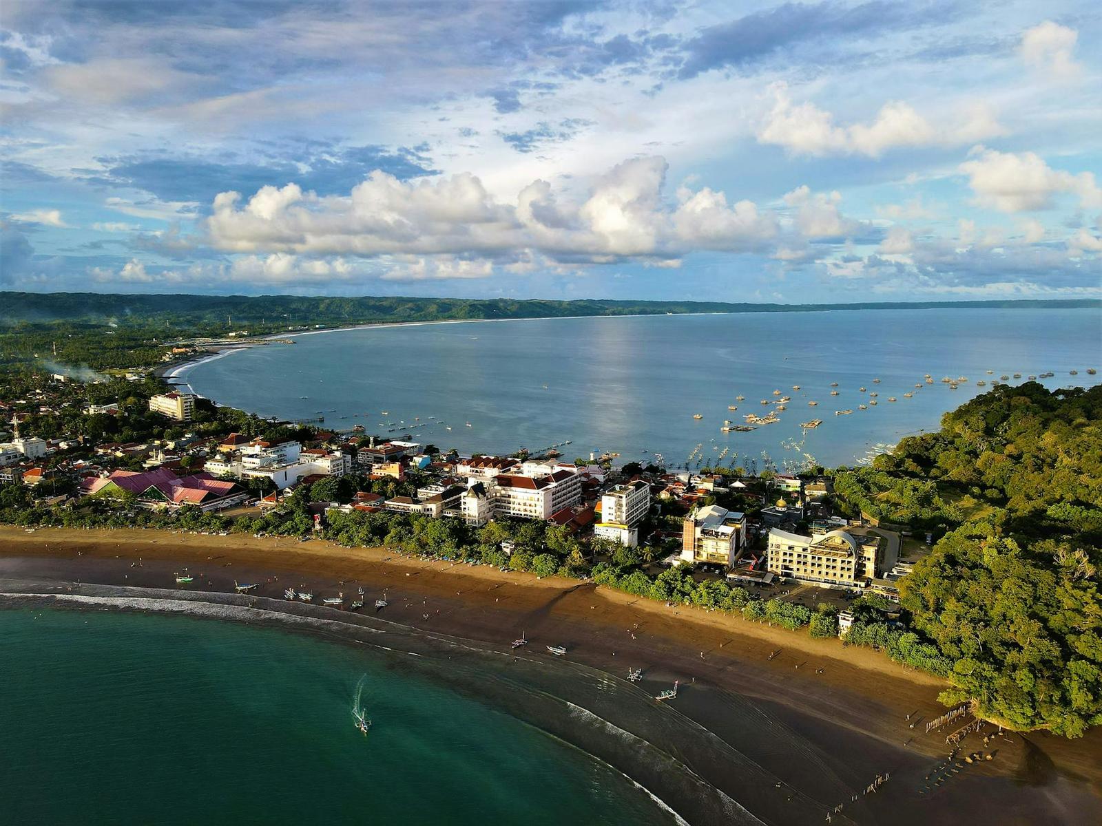 An aerial view of a curved bay lined with a beachfront town