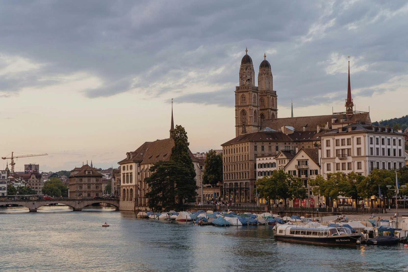 Scenic Zurich cityscape featuring the Grossmünster church along the Limmat River at dusk