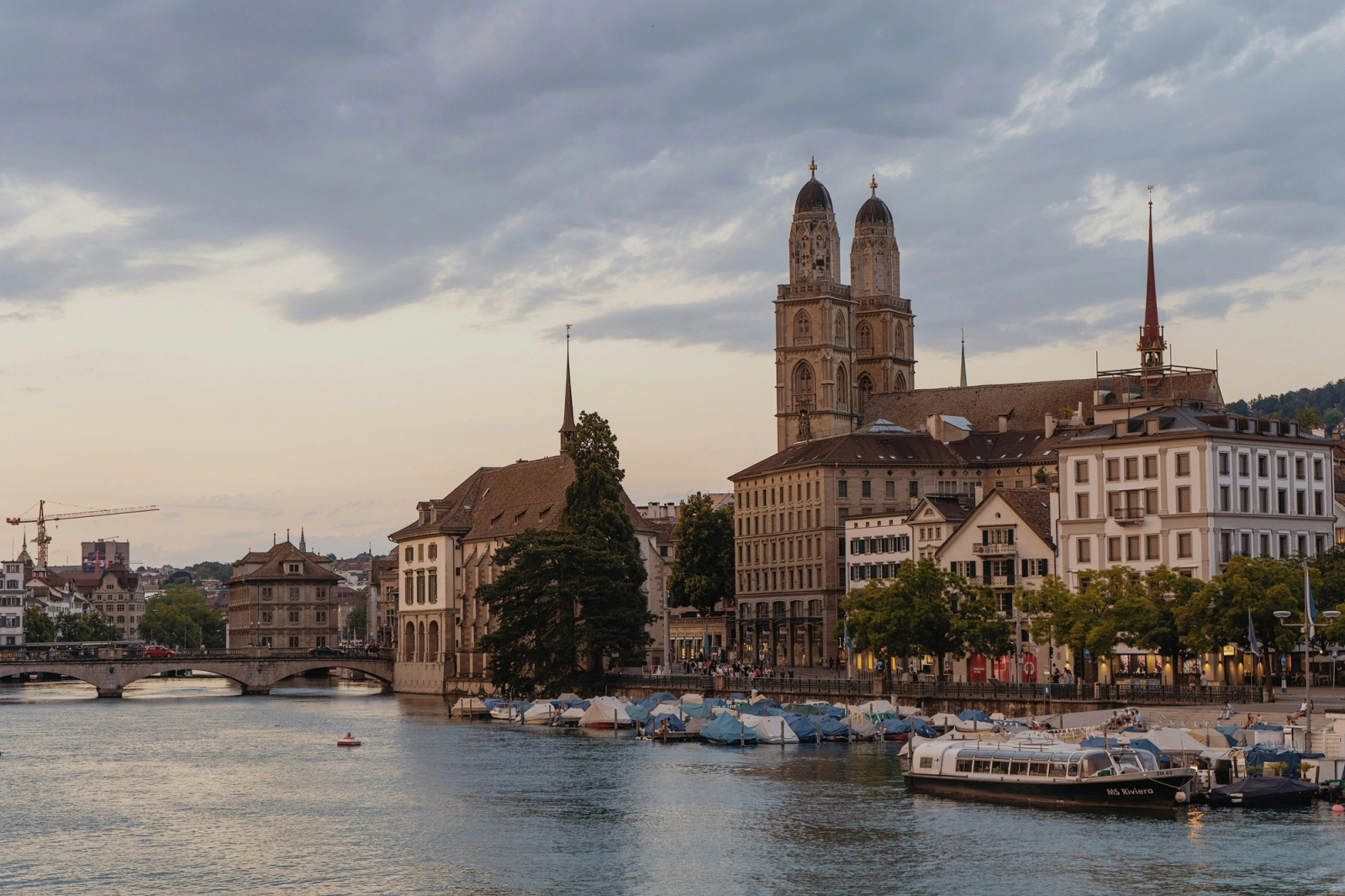 Scenic Zurich cityscape featuring the Grossmünster church along the Limmat River at dusk