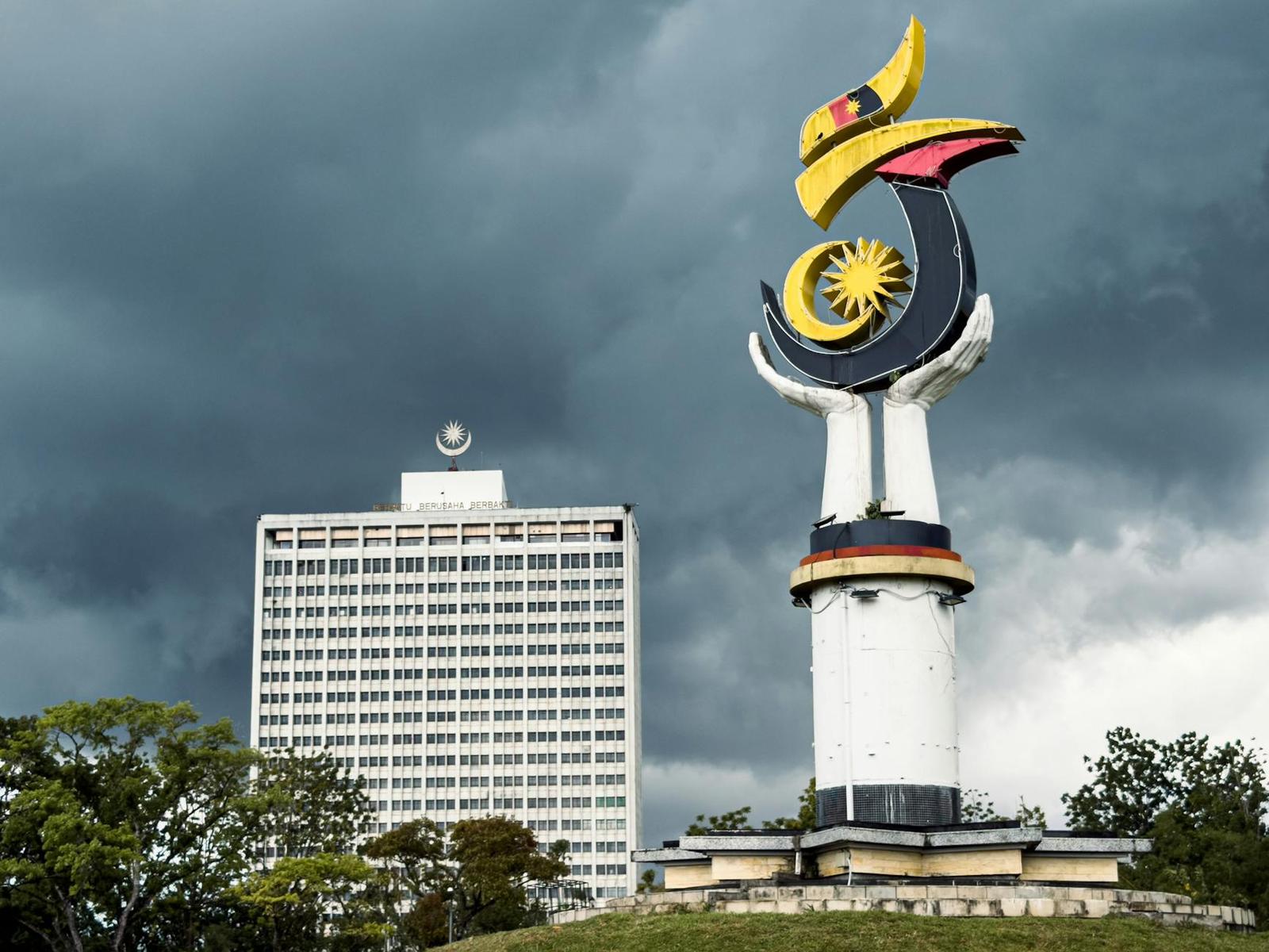 View of the unique monument and Wisma Bapa Malaysia building under dramatic clouds
