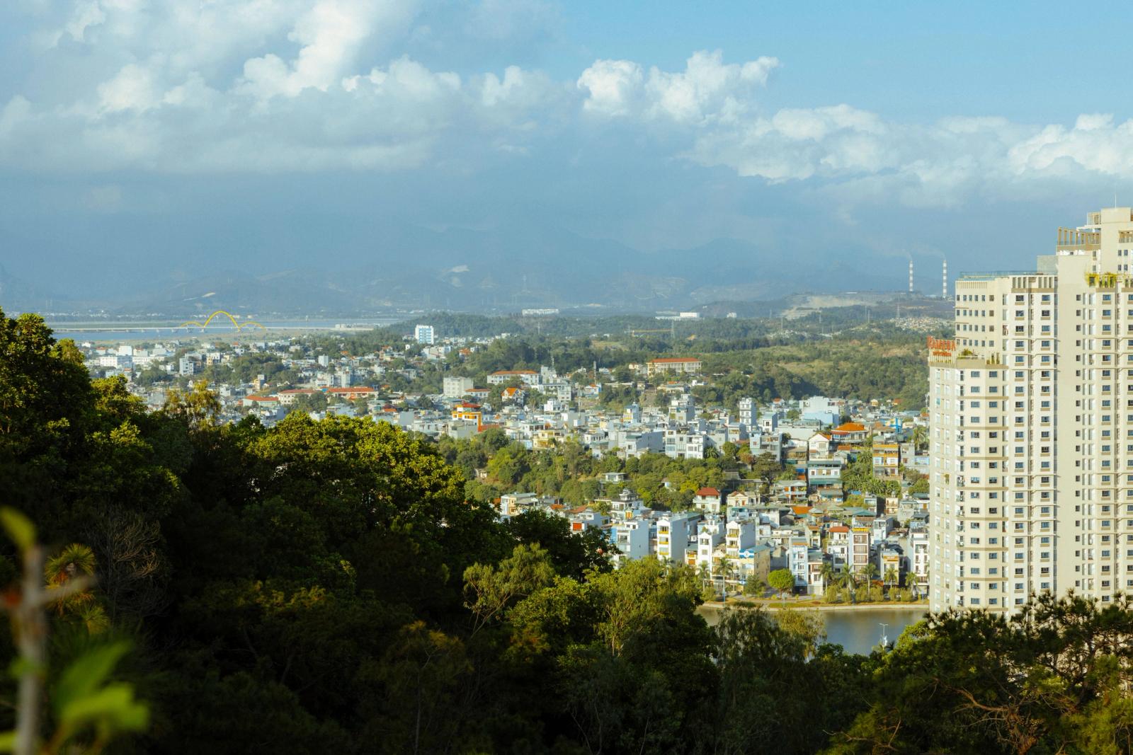 Aerial view of a vibrant city in Vietnam with high-rise buildings and lush greenery