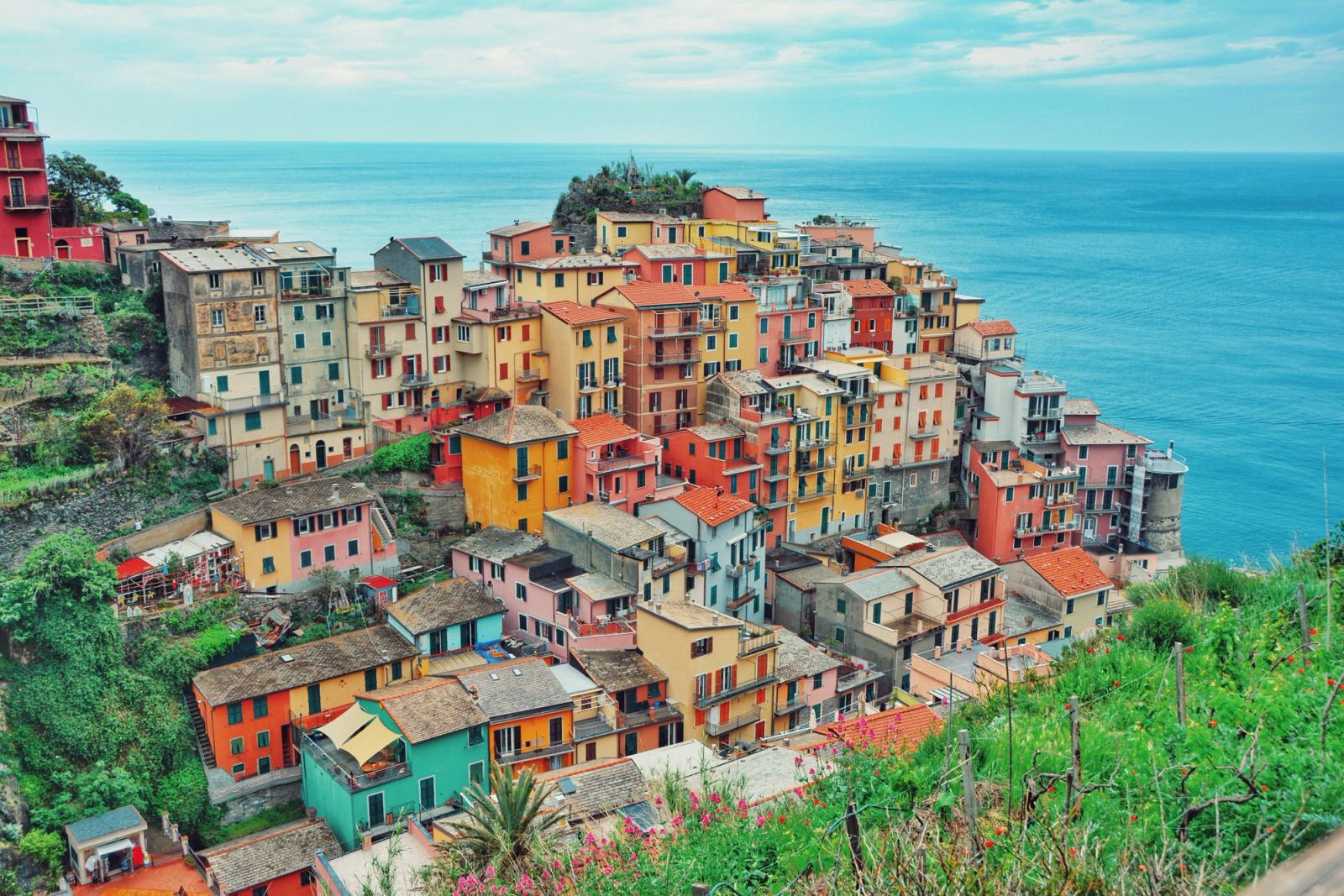 Colourful stacked houses on a cliff above the sea