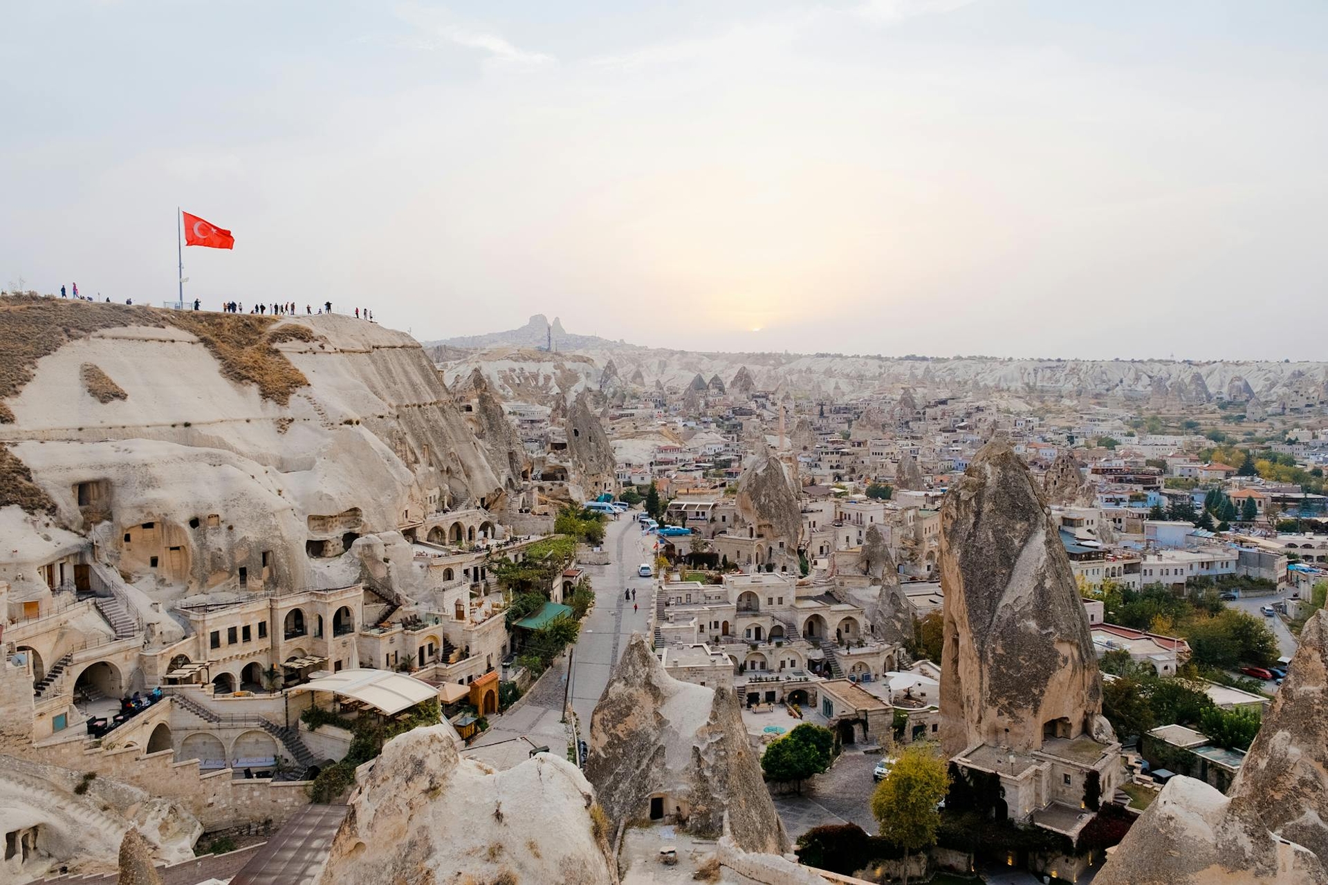 Cave dwellings carved into cone-shaped rock formations above a valley town