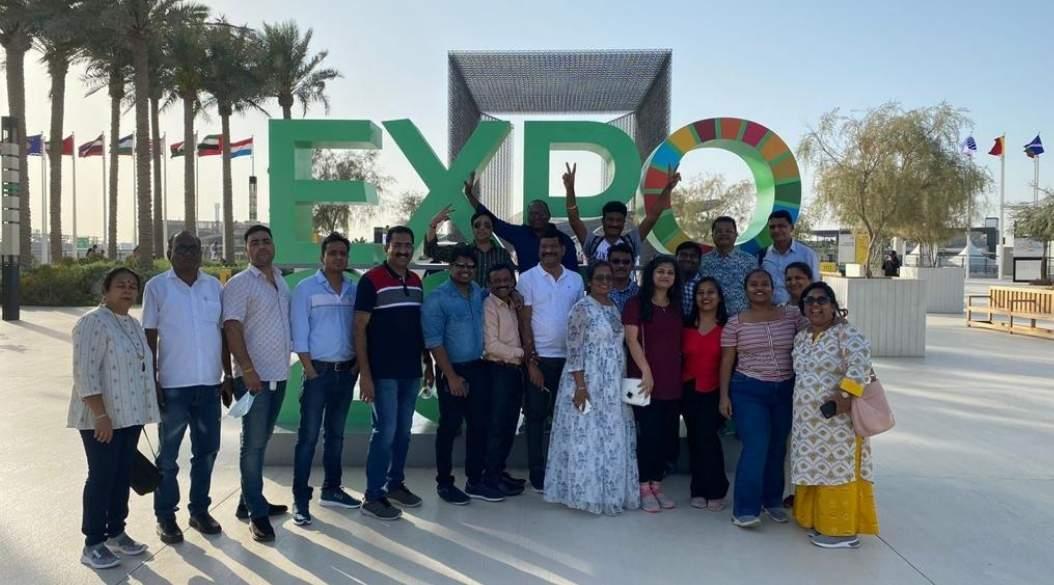 Group of people posing in front of an expo sign.