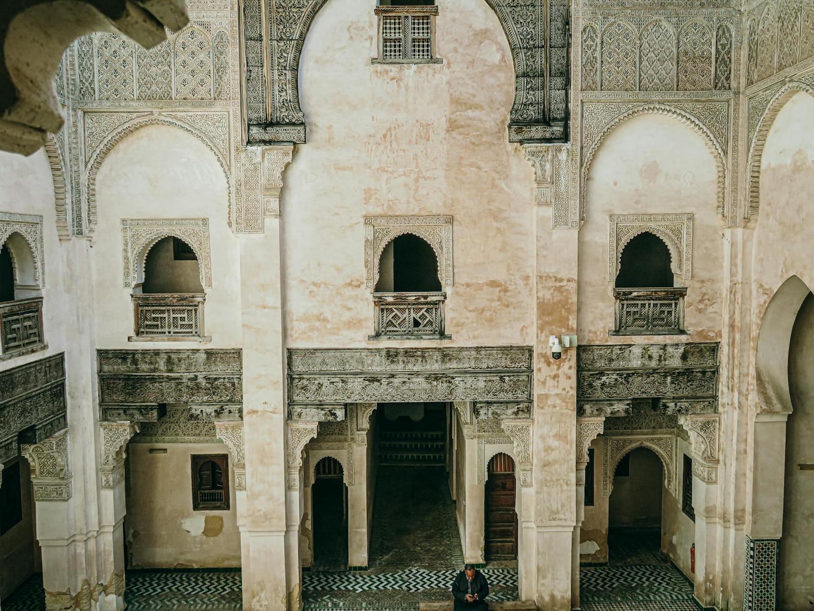 Ornately carved arches and balconies surrounding a courtyard, seen from above
