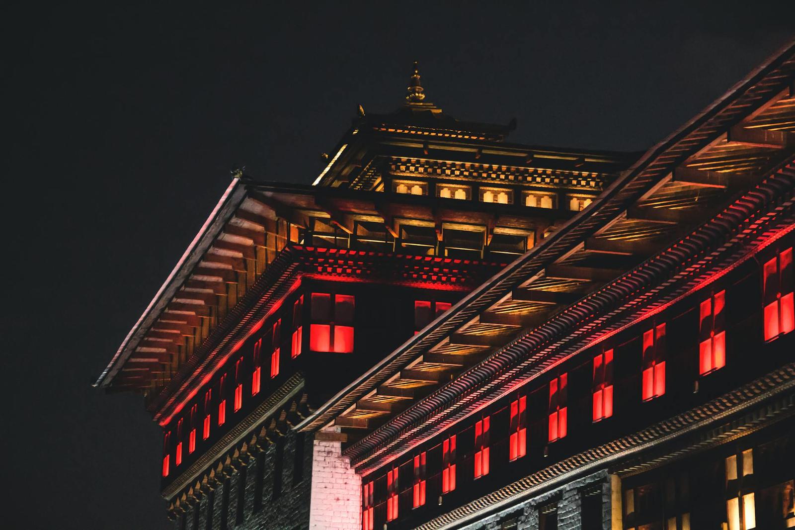 A vibrant night view of traditional Bhutanese architecture illuminated in Thimphu, Bhutan