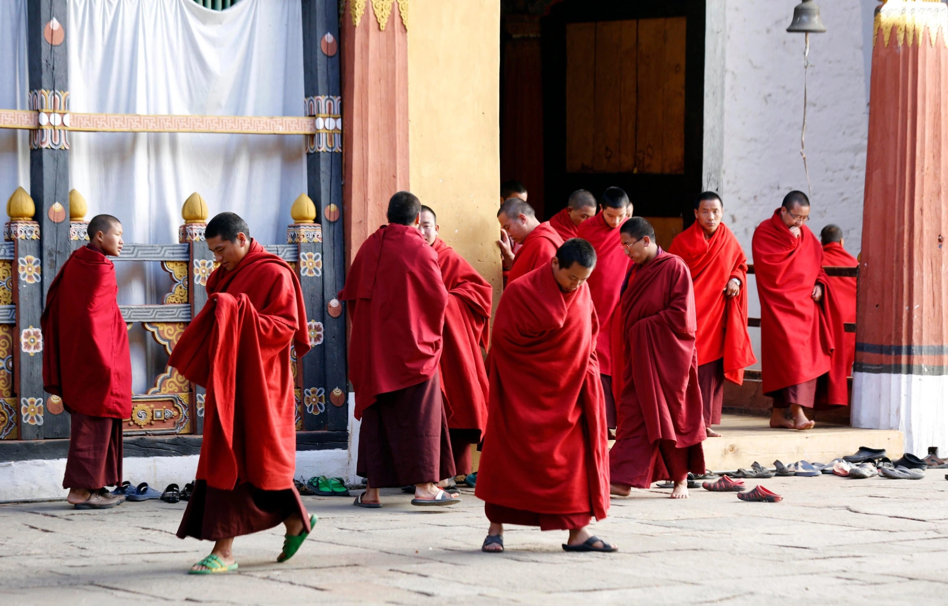 Buddhist monks in red robes gather at Trongsa Monastery, Bhutan, showcasing traditional culture