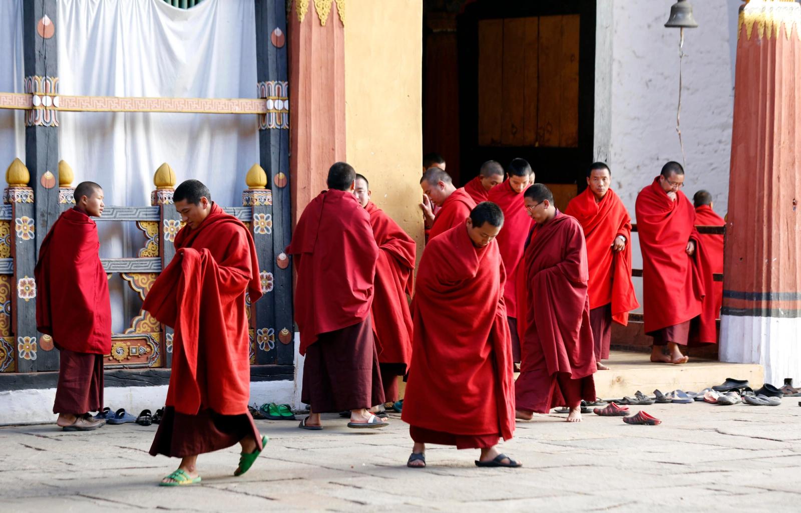 Buddhist monks in red robes gather at Trongsa Monastery, Bhutan, showcasing traditional culture