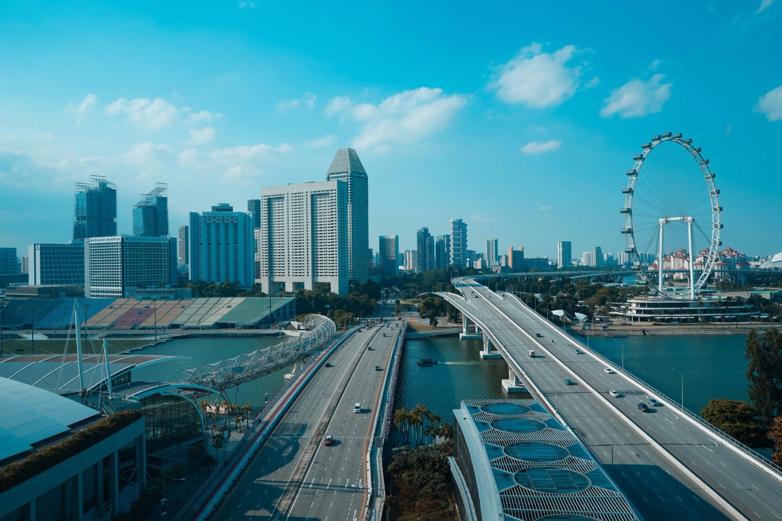Scenic aerial shot of Singapore's skyline featuring the Helix Bridge, Marina Bay, and Singapore Flyer