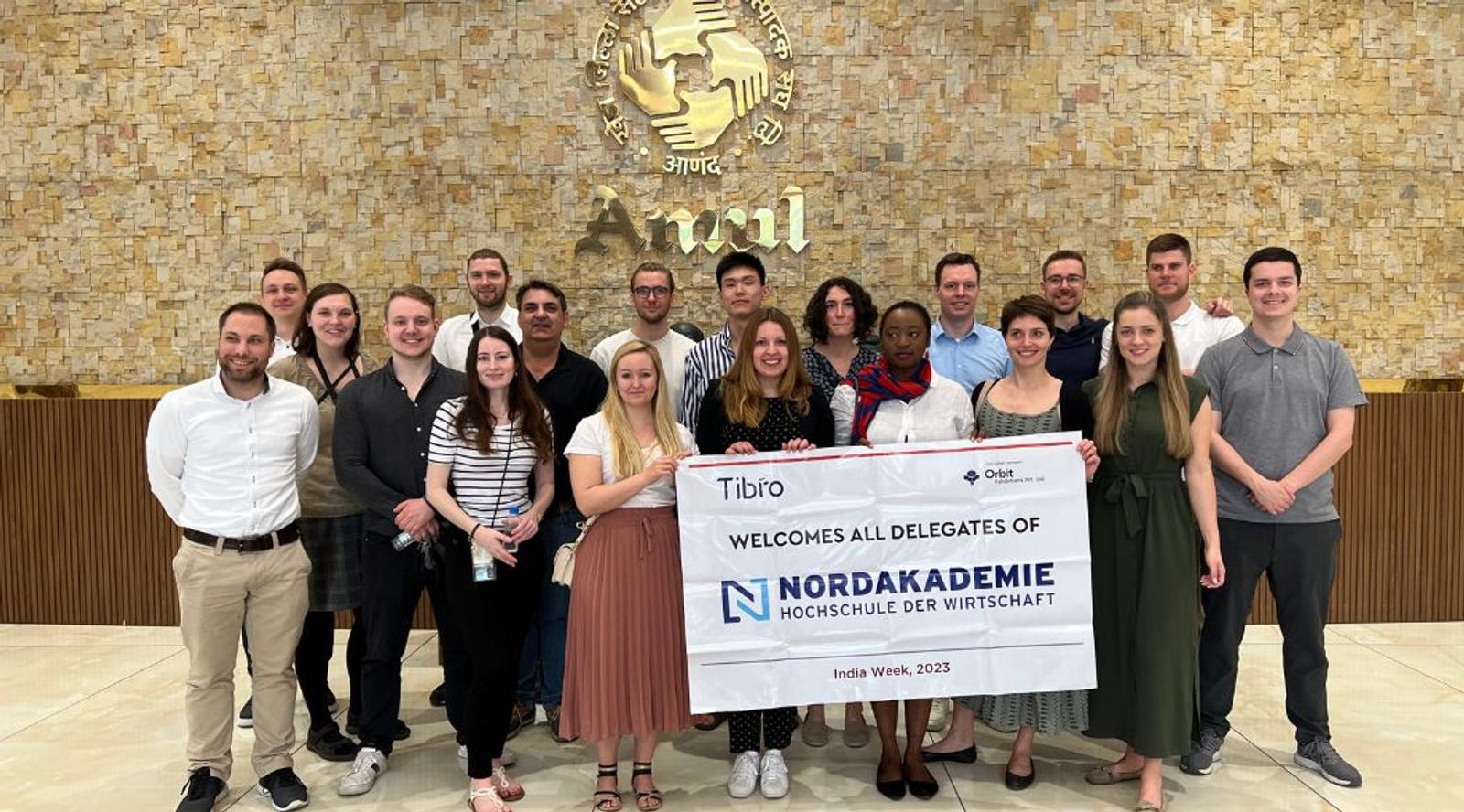 Group of people celebrating while presenting a large check