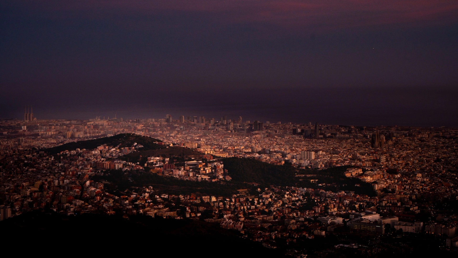 Aerial view of Barcelona illuminated at night, showcasing its urban landscape and vibrant city lights