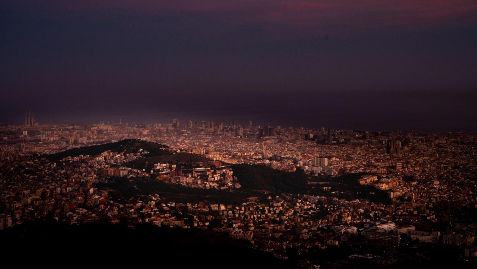 Aerial view of Barcelona illuminated at night, showcasing its urban landscape and vibrant city lights