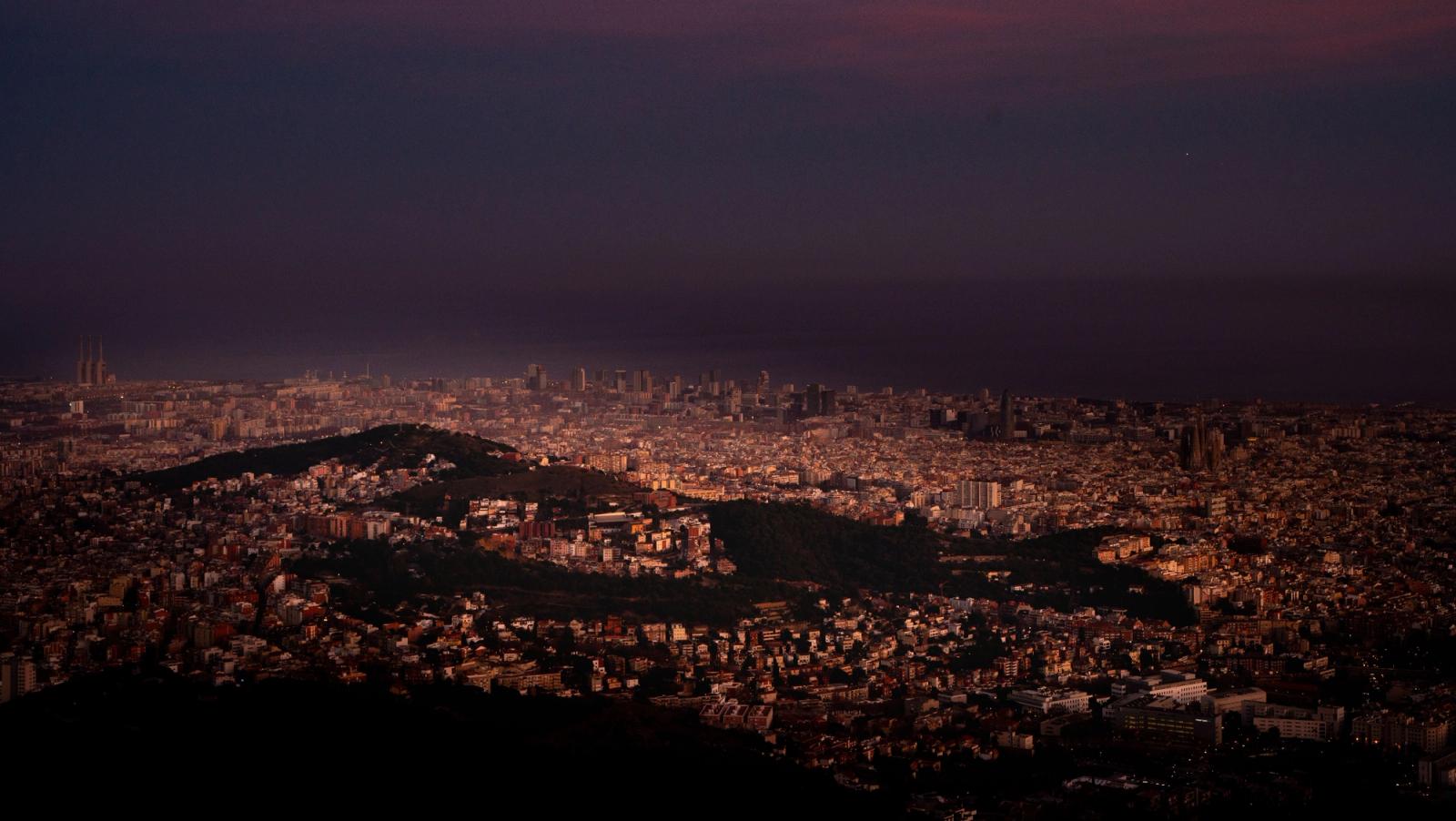 Aerial view of Barcelona illuminated at night, showcasing its urban landscape and vibrant city lights