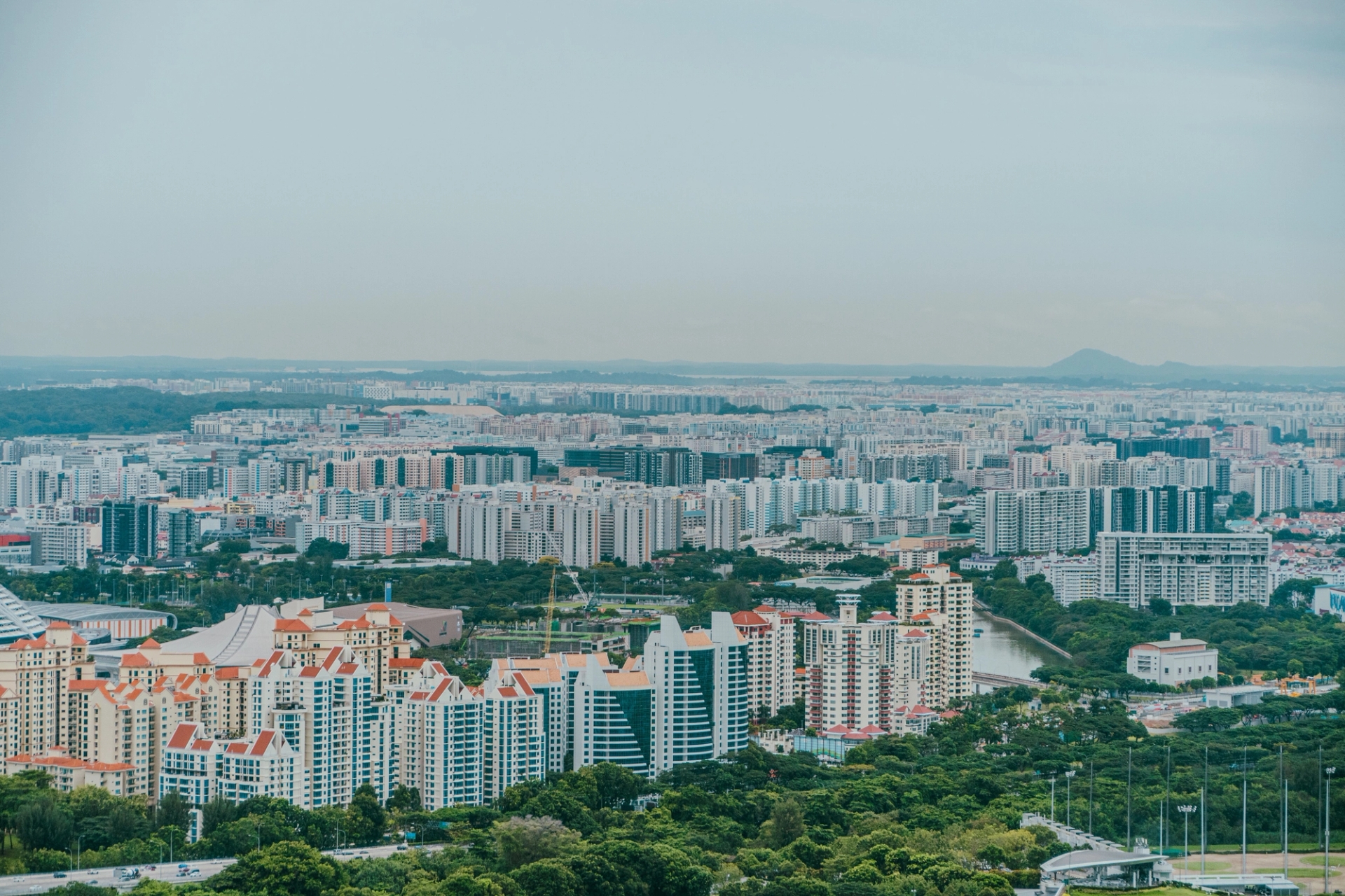 A panoramic aerial view showcasing the dense urban sprawl of Singapore's skyline with modern architecture