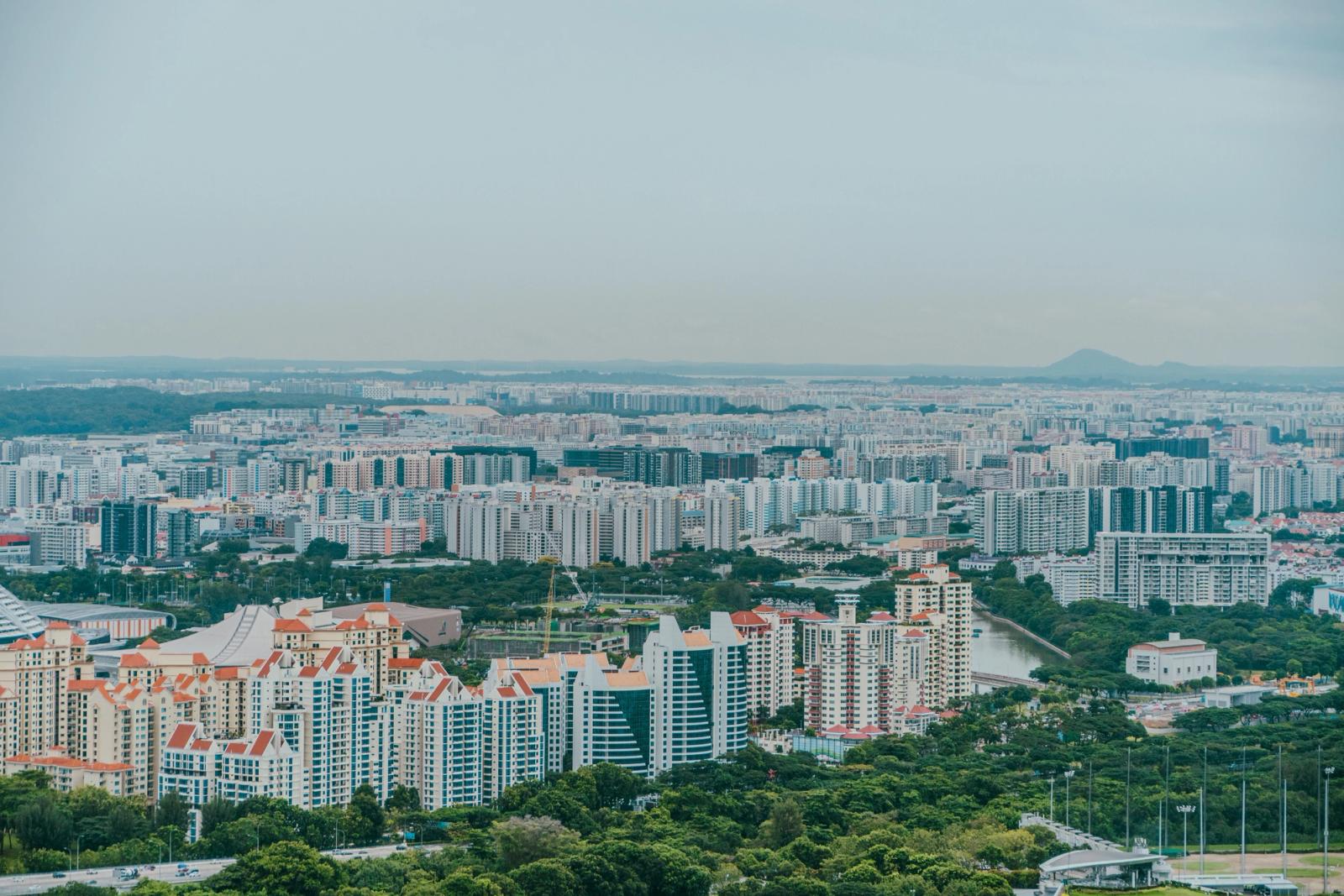 A panoramic aerial view showcasing the dense urban sprawl of Singapore's skyline with modern architecture
