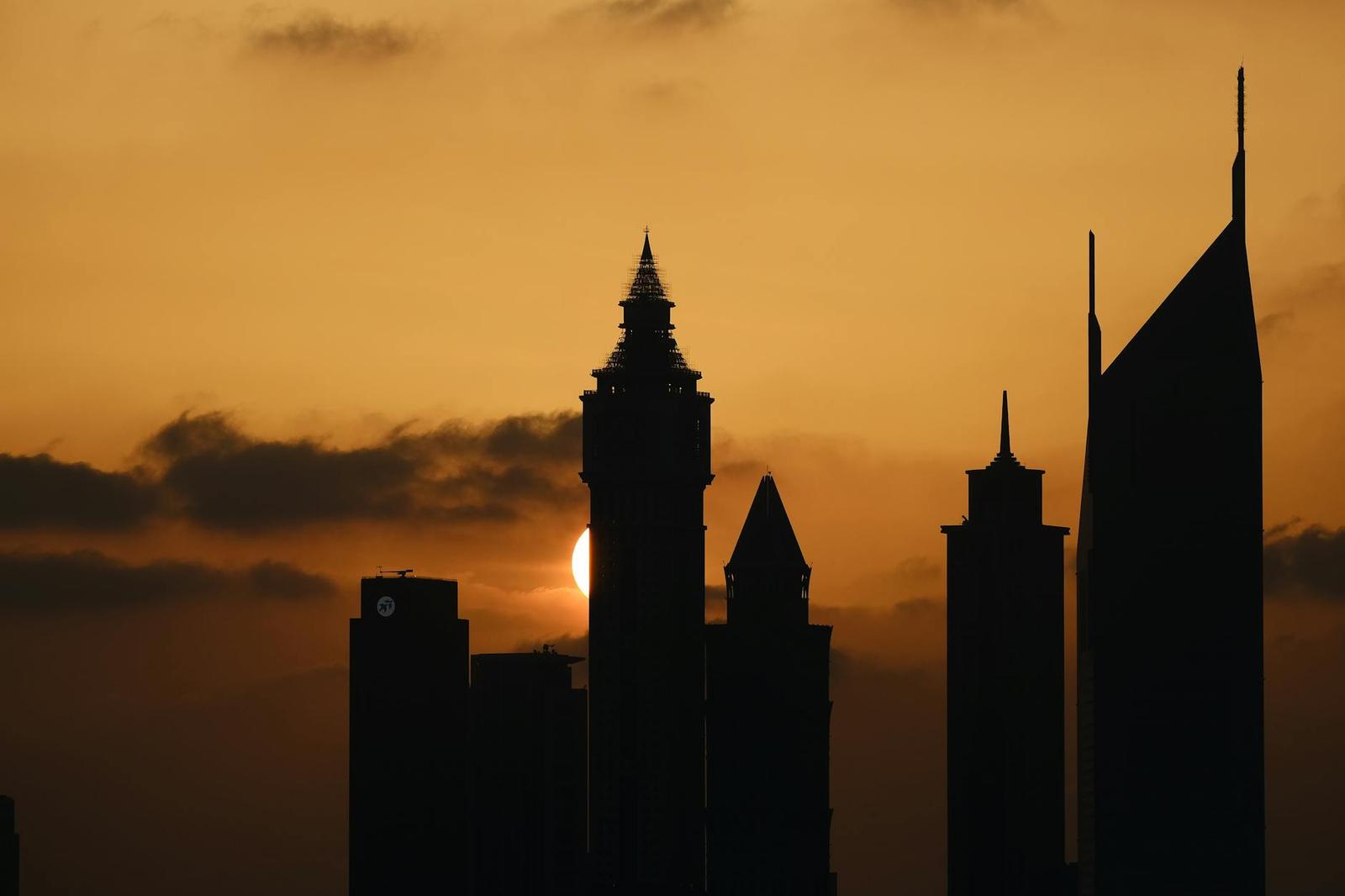 Silhouette of Dubai's iconic skyline against a dramatic sunset