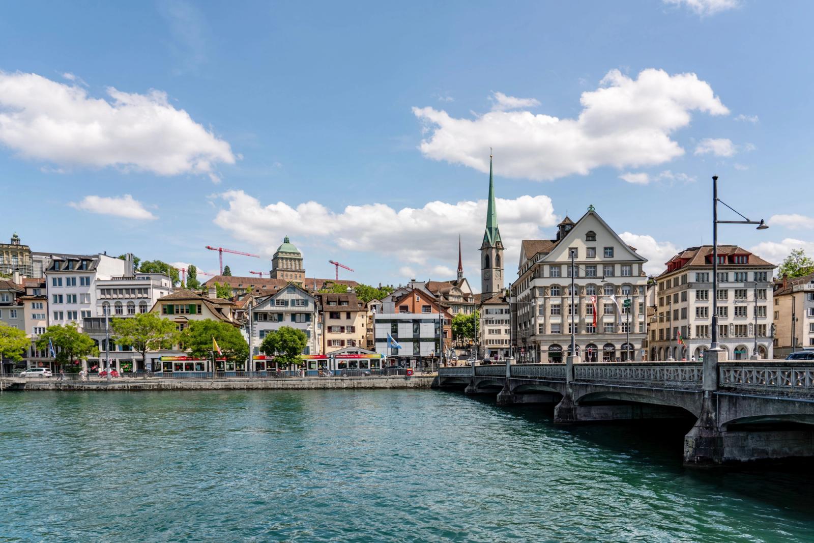 Charming view of Zurich with historic buildings along the Limmat River under a clear blue sky