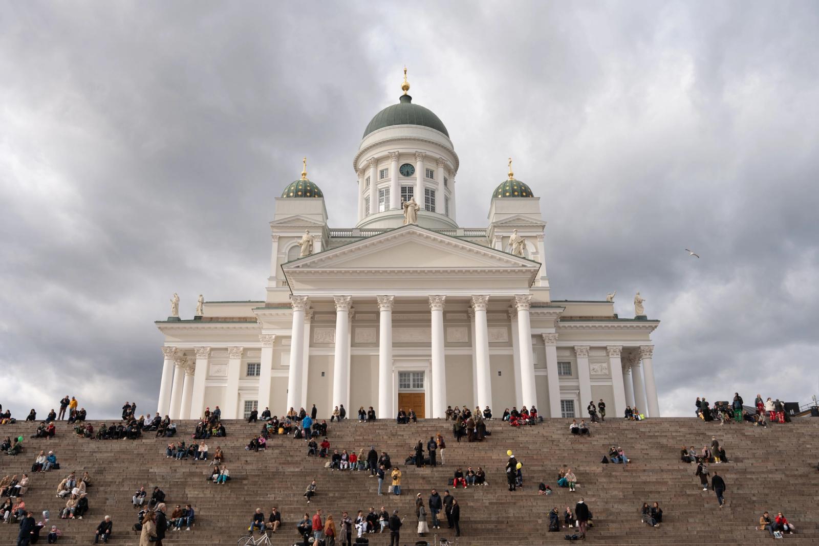 Crowds gather on the steps of Helsinki Cathedral under dramatic skies. Iconic Helsinki landmark