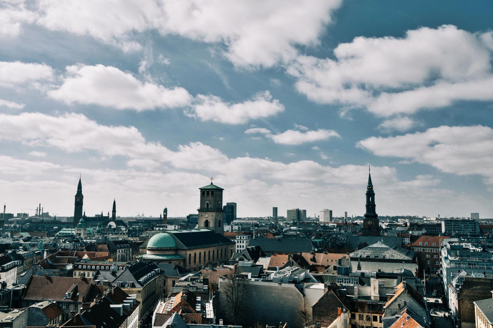 Stunning aerial view of Copenhagen's cityscape under a vibrant blue sky, showcasing historic spires and architecture