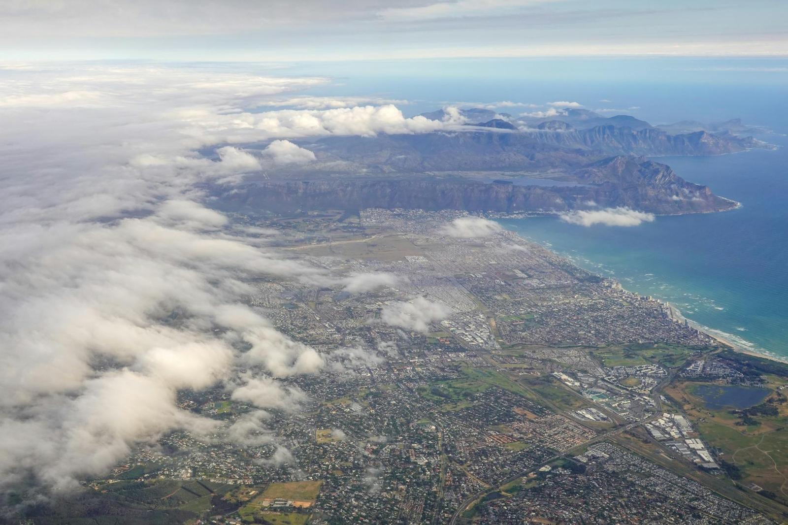 Aerial view of a cloud-draped mountain range along the coast