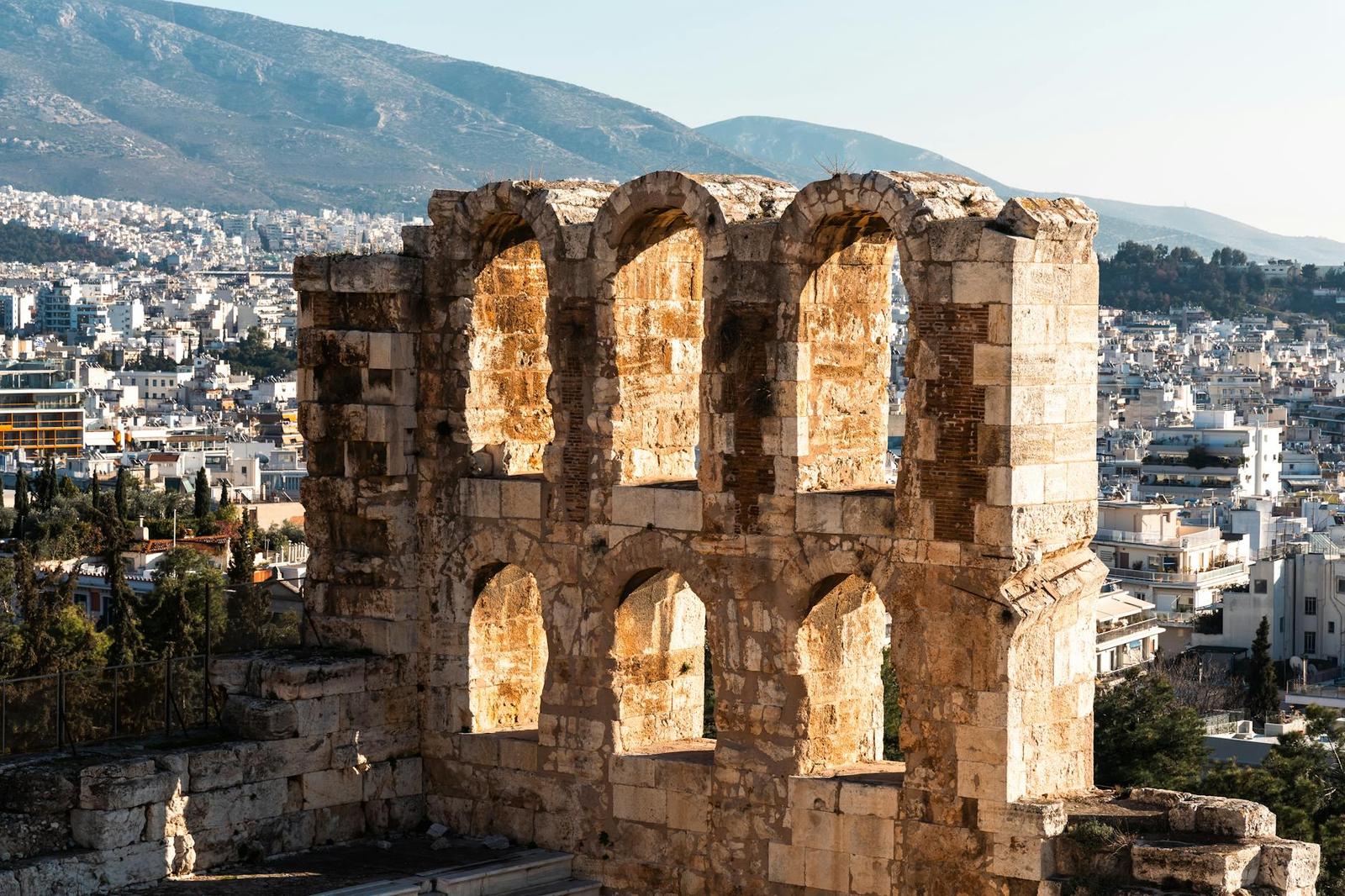 View of the ancient Odeon of Herodes Atticus in Athens with a cityscape backdrop