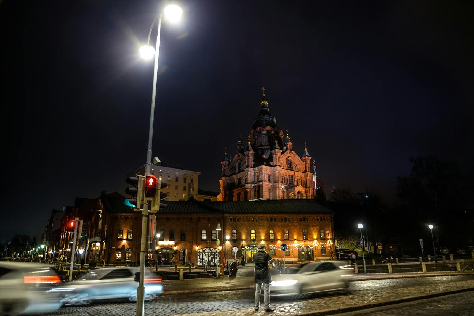 Ornate onion-domed cathedral lit up at night above a busy street