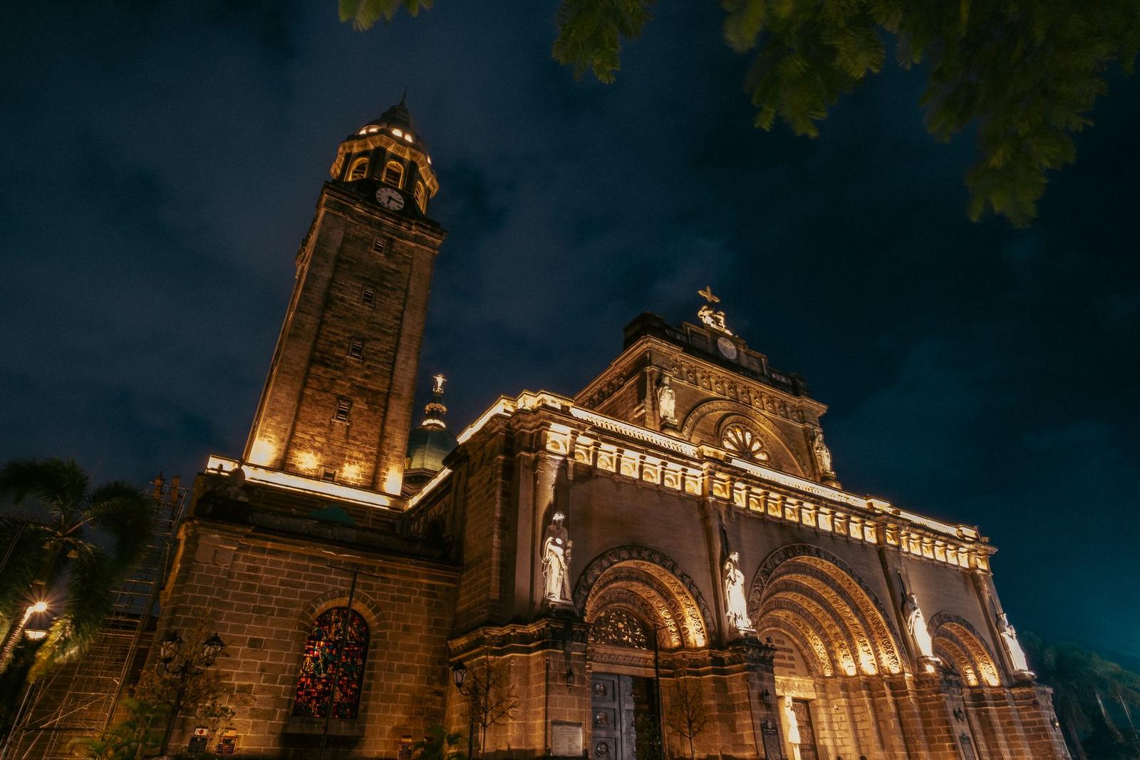 A dramatic night view of the illuminated Manila Cathedral showcasing its architectural beauty