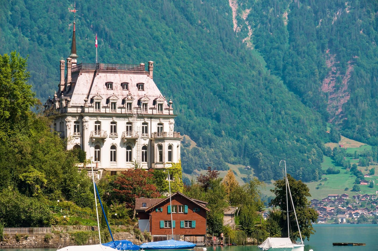 A picturesque view of Seeburg Castle surrounded by lush greenery and Lake Brienz