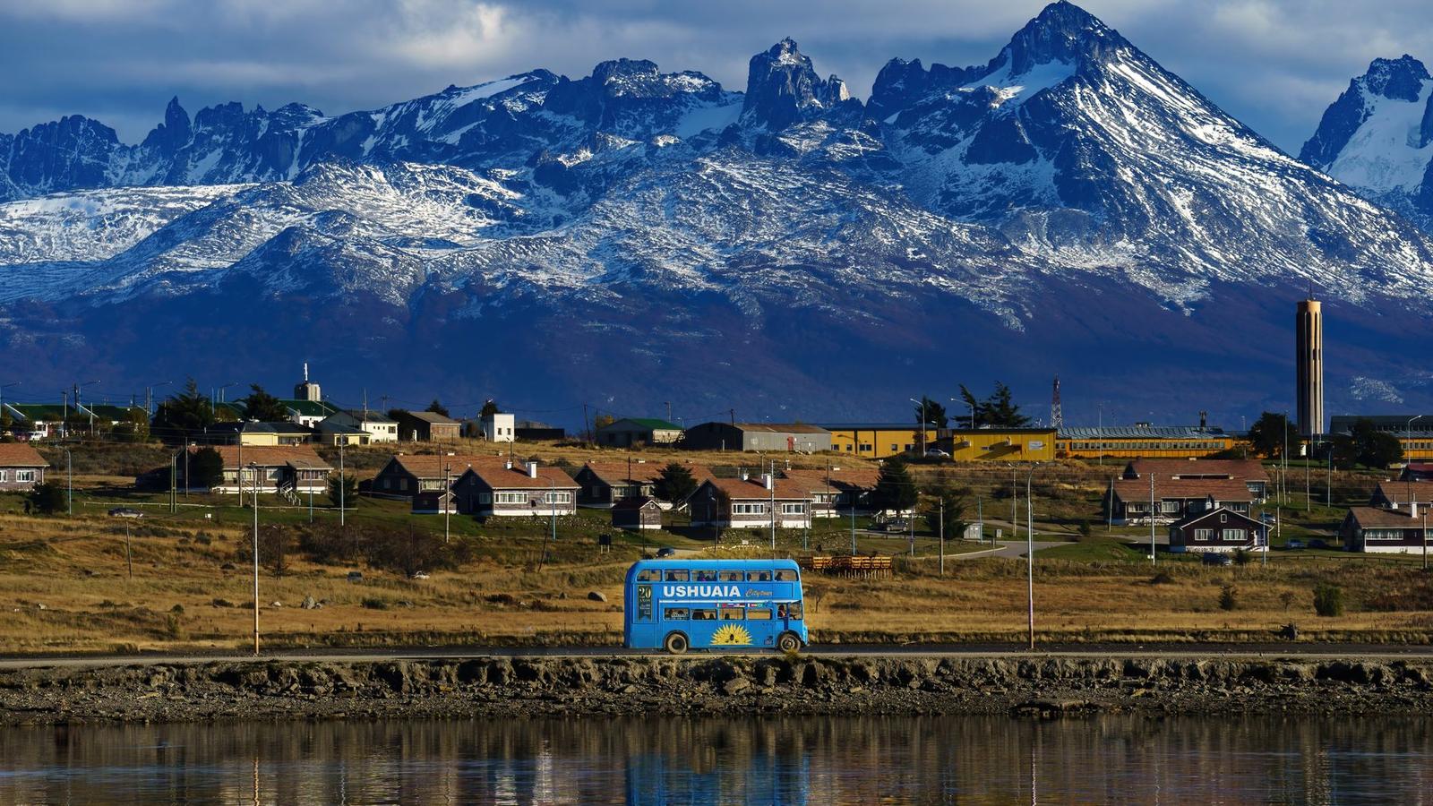 Ushuaia cityscape with a blue bus and stunning snowy mountain backdrop in Argentina