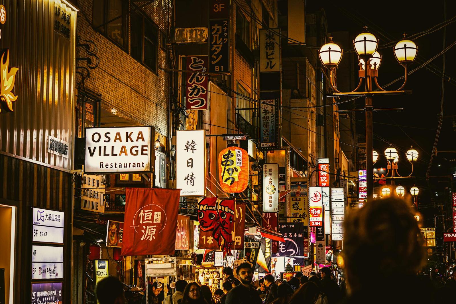 A crowded night market street strung with glowing neon signage