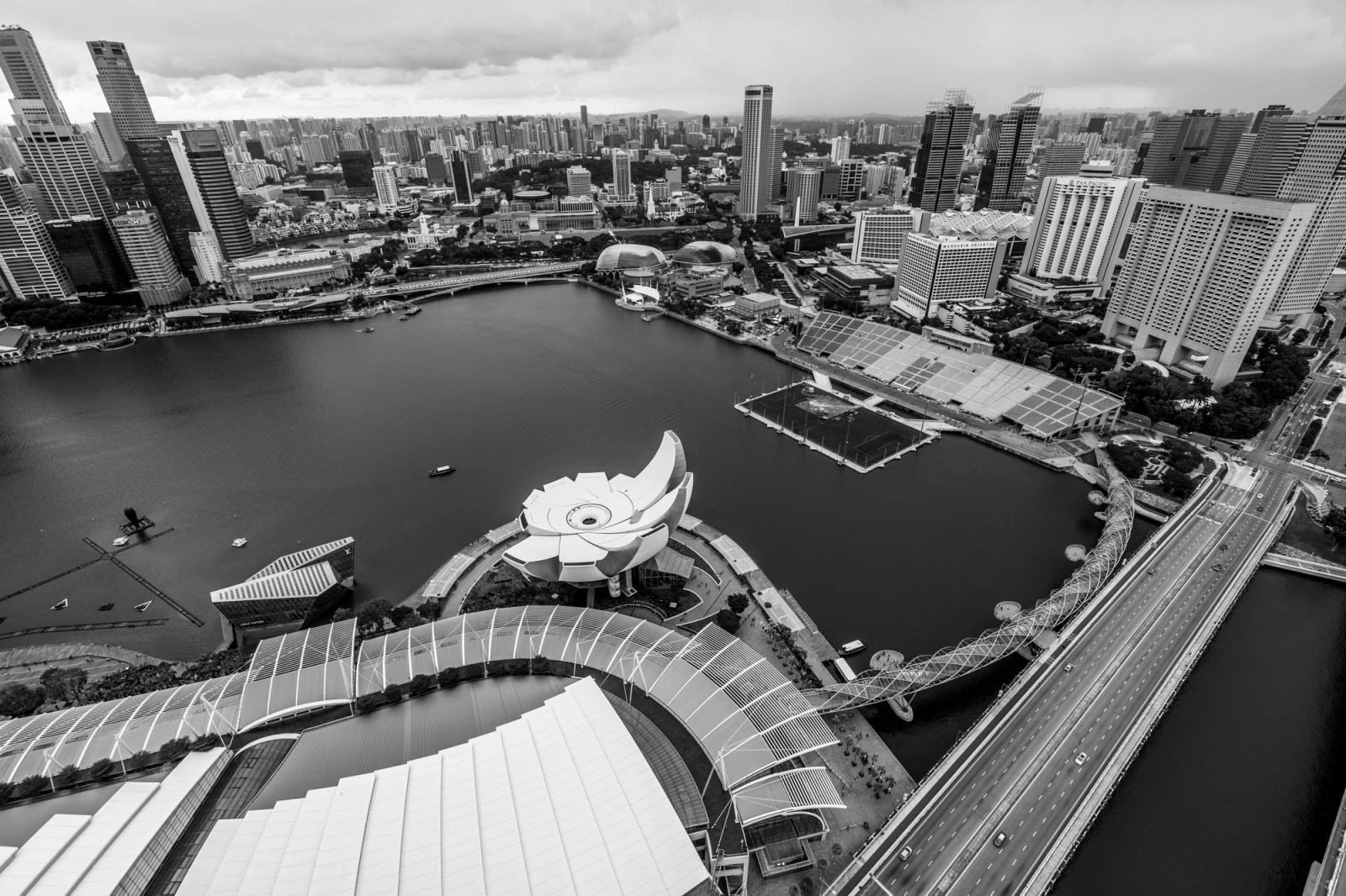 Stunning aerial view of Marina Bay area in Singapore captured in black and white, showcasing architecture and the ArtScience Museum